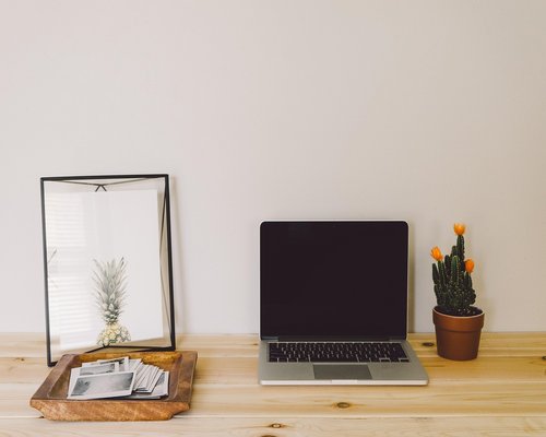 A desk setup in a modern Quito office showing a laptop and plants